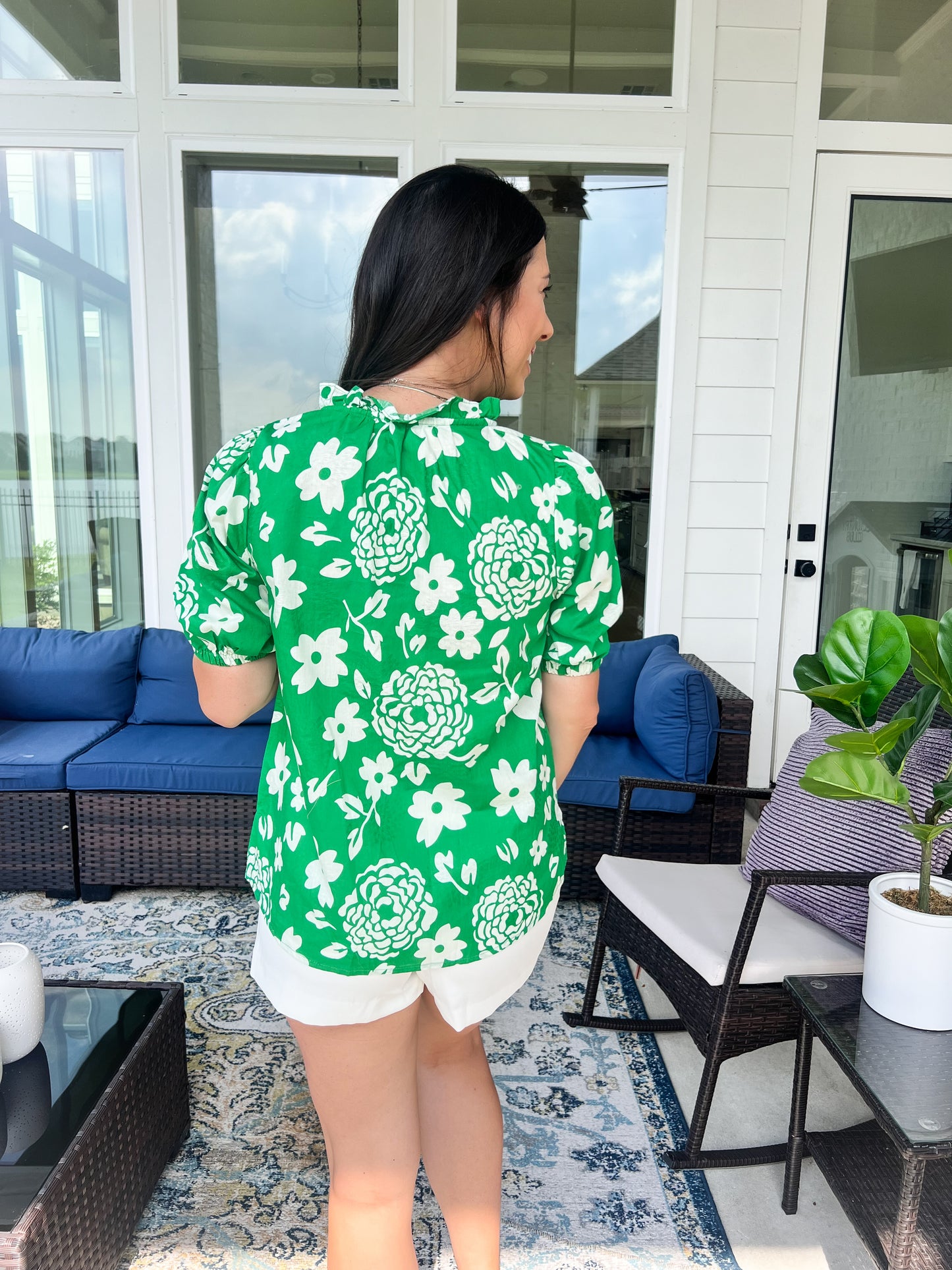 Back of green and white floral top with sleeves