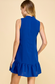 Back of model in high neck royal blue dress with ruffle at bottom