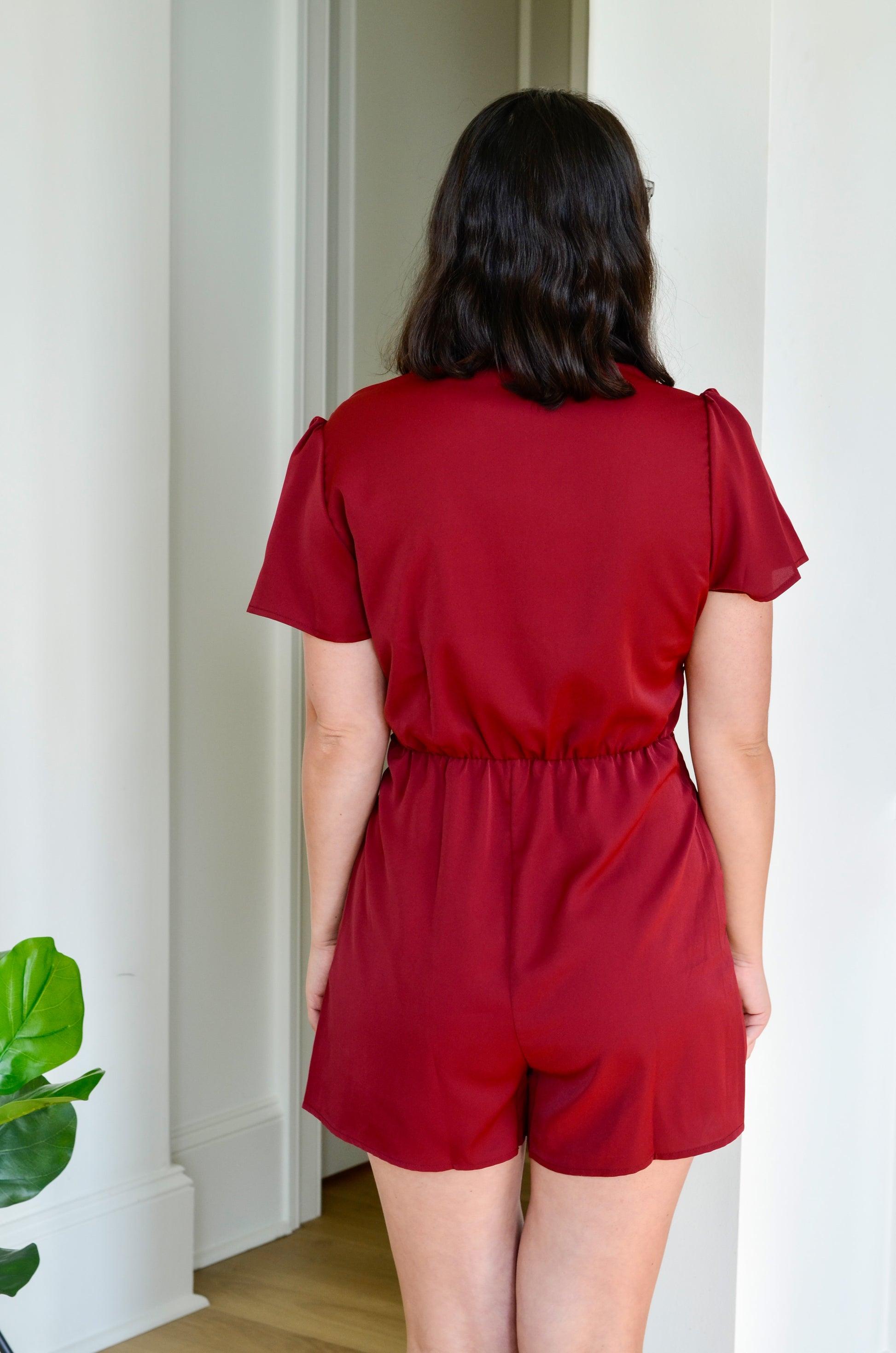 Back of burgundy romper with tie at the waist 