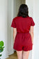 Back of burgundy romper with tie at the waist 