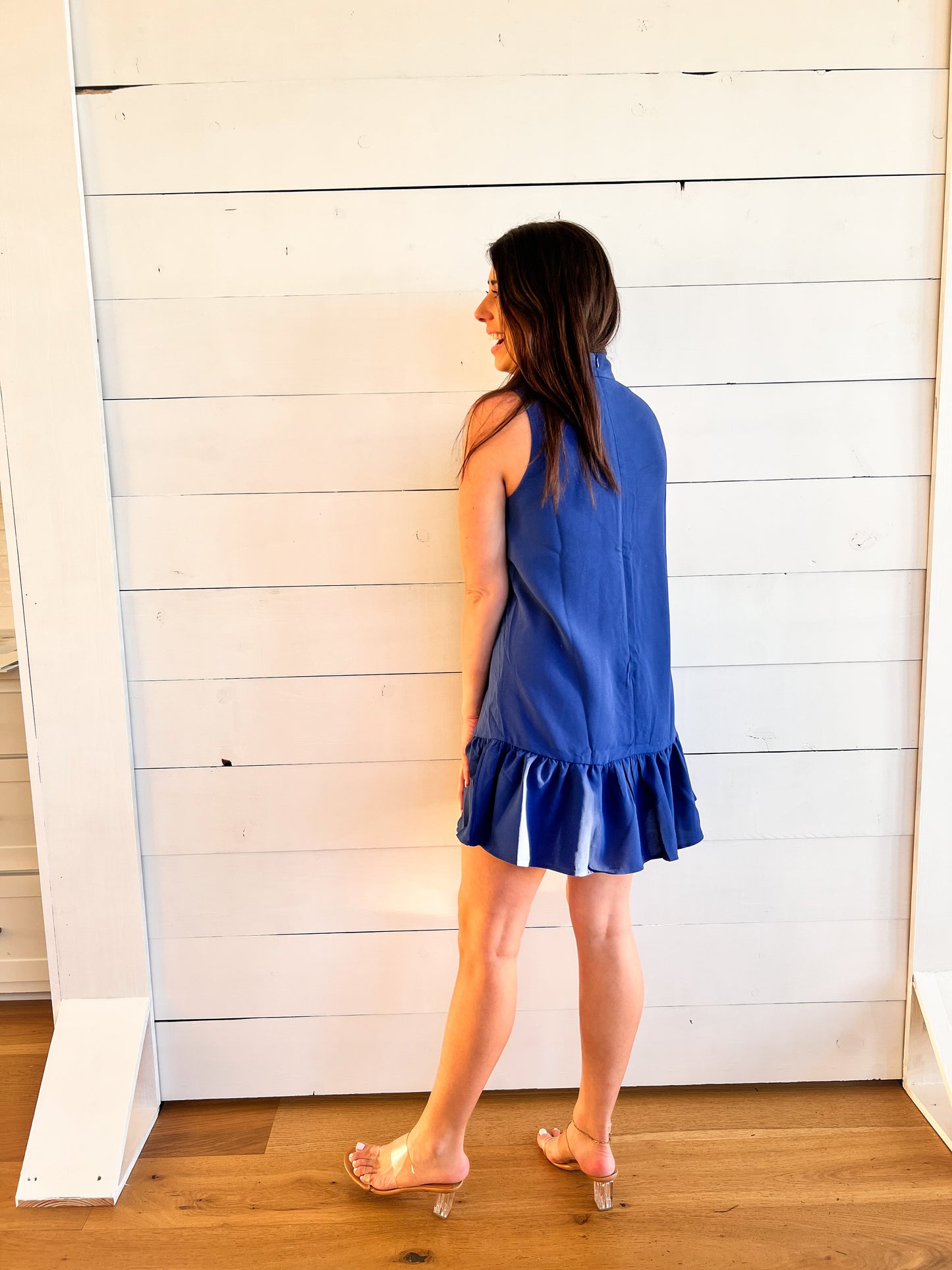 Back of high neck royal blue dress with ruffle at bottom