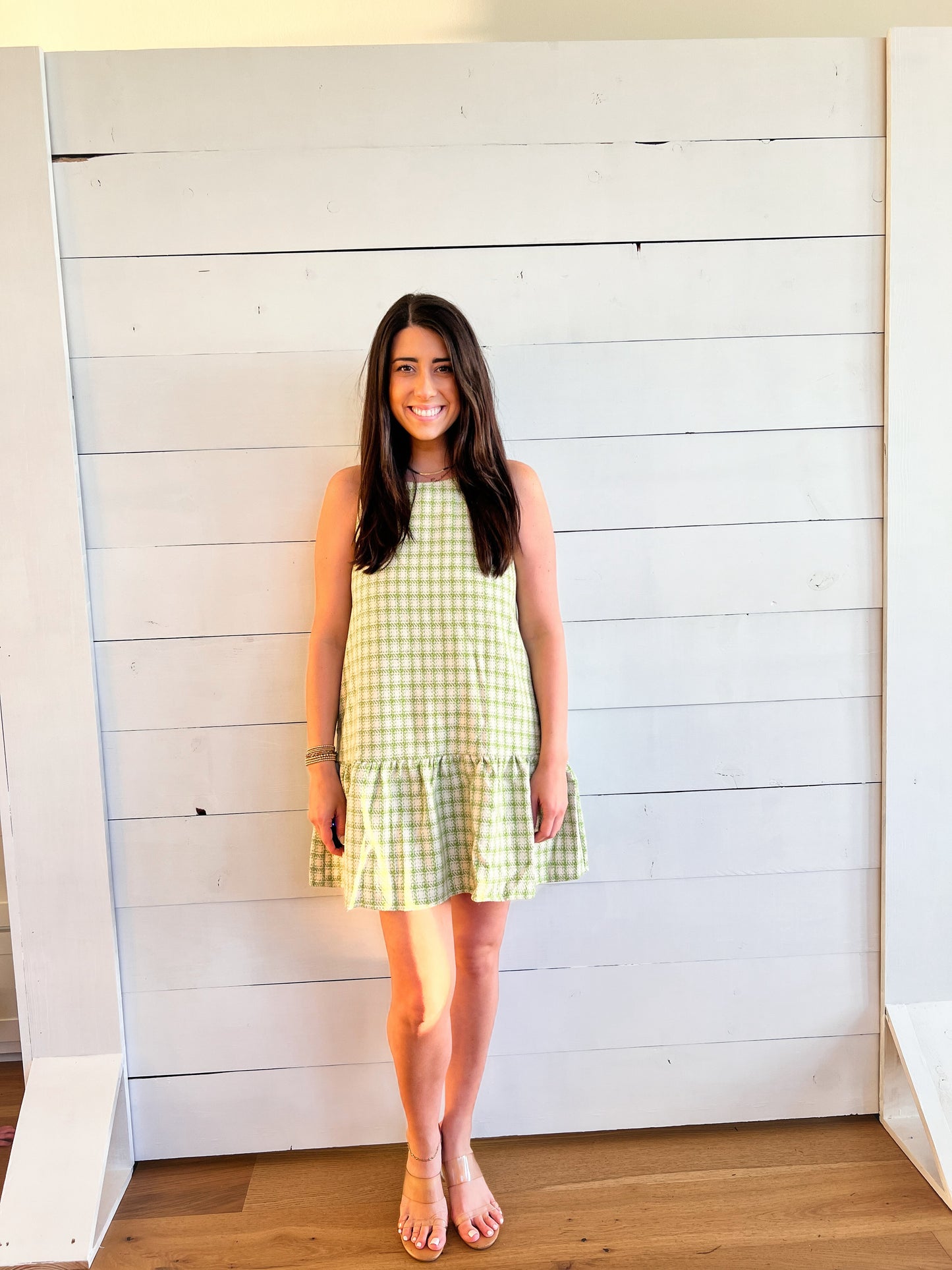 Front of green and white plaid dress with ruffle at bottom